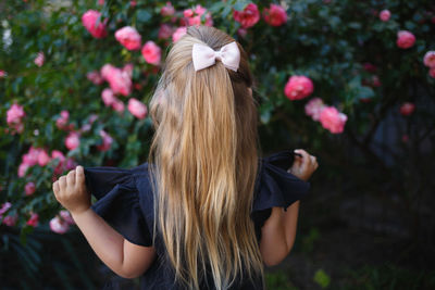 Rear view of girl looking at flowers outdoors