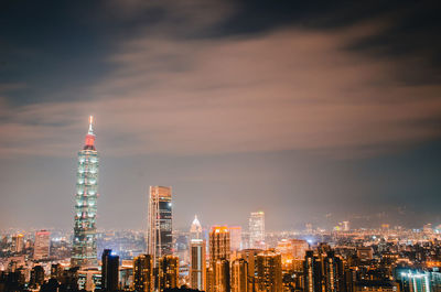 Illuminated modern buildings in city against sky