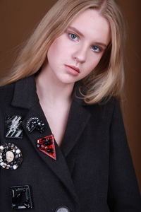 Portrait of beautiful teenager against brown background