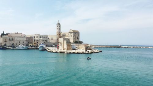 Boats in sea against buildings