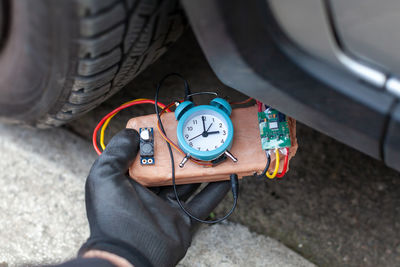Cropped hand of man holding clock