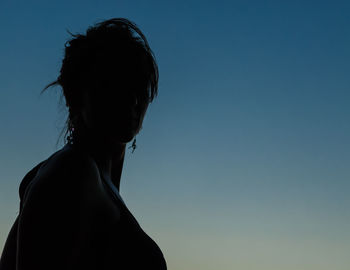 Silhouette woman against blue sky at dusk