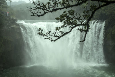 Scenic view of waterfall against sky