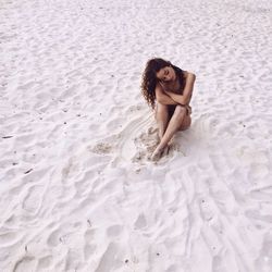 Portrait of young woman on sand at beach