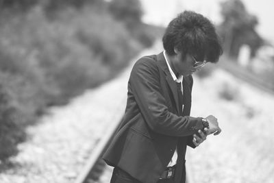 Side view of young man standing outdoors