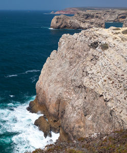 Rock formations by sea against sky