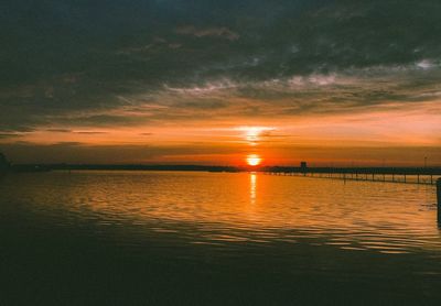 Scenic view of sea against dramatic sky during sunset