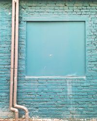 Low angle view of blue window on wall of building