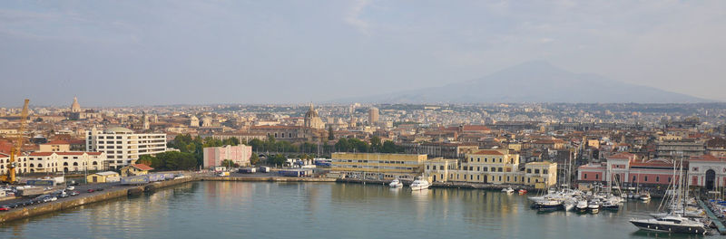 River amidst buildings in city against sky