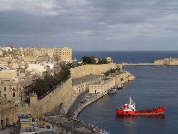 High angle view of buildings by sea against sky