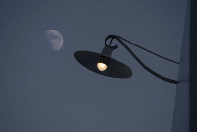 Low angle view of illuminated light bulb against sky at night