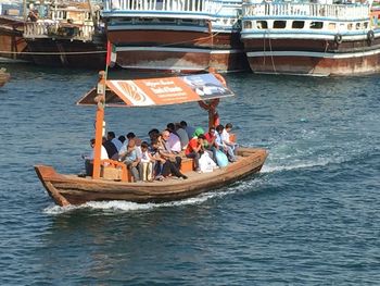 People in boat sailing in sea