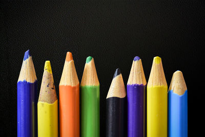 Close-up of colored pencils against black background