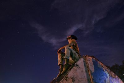 Low angle view of person against sky at night