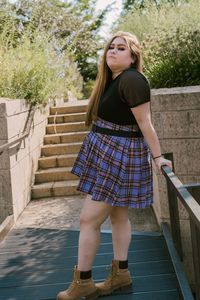 Portrait of teenage girl standing against staircase