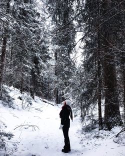 Full length of woman standing on snow covered field