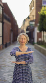 Portrait of smiling woman with umbrella on building in city