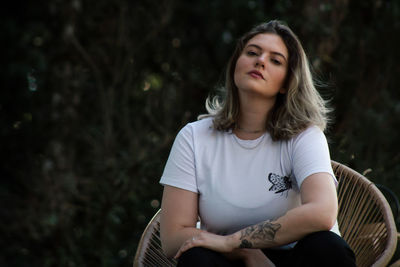 Portrait of beautiful young woman sitting outdoors