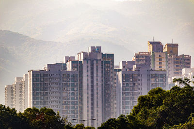 Buildings in city against cloudy sky