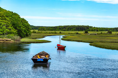 Boat moored on lake against sky