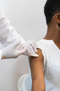 Close up of crop medic making injection for black female patient