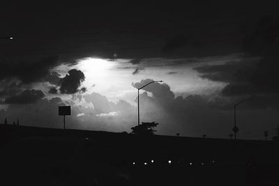 Street light against cloudy sky