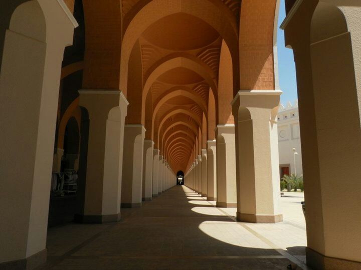 architecture, indoors, the way forward, built structure, arch, corridor, diminishing perspective, ceiling, architectural column, in a row, empty, column, colonnade, narrow, vanishing point, building, archway, lighting equipment, building exterior, flooring