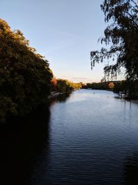 Scenic view of river against sky at sunset