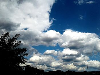 Low angle view of silhouette trees against blue sky