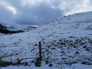 Scenic view of snow covered land against sky