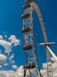 Low angle view of ferris wheel against blue sky