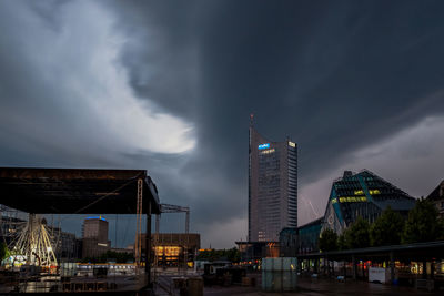 Illuminated buildings in city against sky at dusk