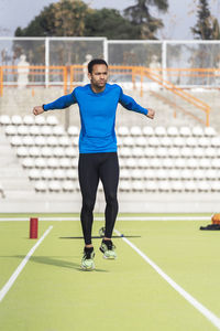 Full length of man warming up at sports field