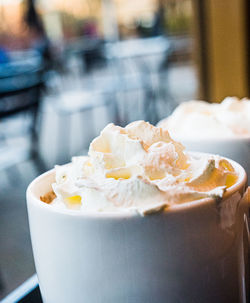 Close-up of a mug of hot chocolate with cream on a table