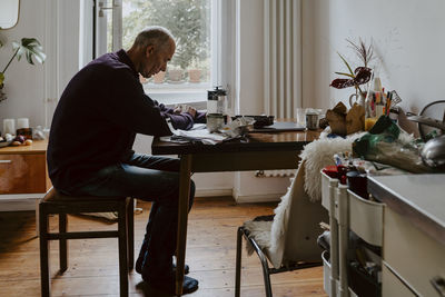 Emotionally stressed man at table in living room