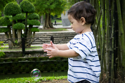 Side view of boy playing with plants