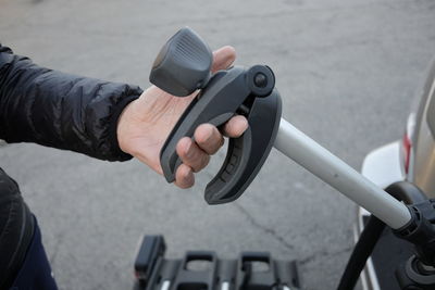 Close-up of hand refueling car on street