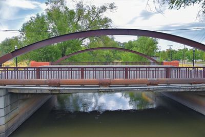 Arch bridge over river against sky