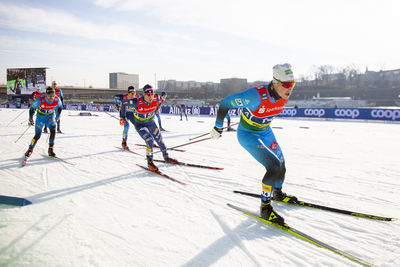 People skiing on snowy field against sky