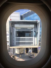 Passenger boarding bridge seen through airplane window