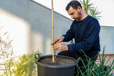 Man working on potted plant at yard