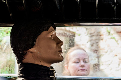 Portrait of man and woman looking through window