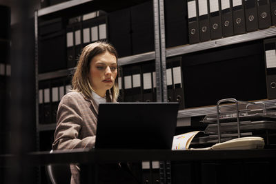 Portrait of young woman using laptop at office