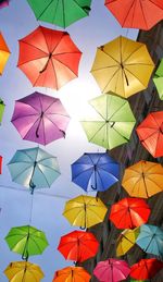 Low angle view of umbrellas hanging against sky