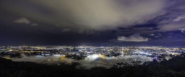 High angle view of illuminated cityscape against sky at night