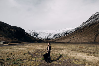 Man standing on snowcapped mountain against sky