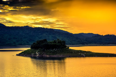 Scenic view of river against sky at sunset