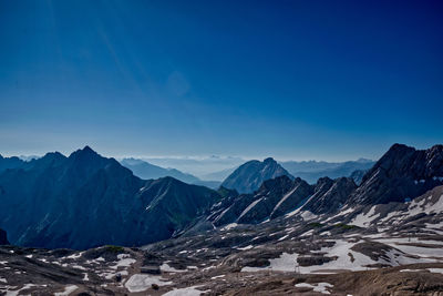 Scenic view of snowcapped mountains against clear blue sky