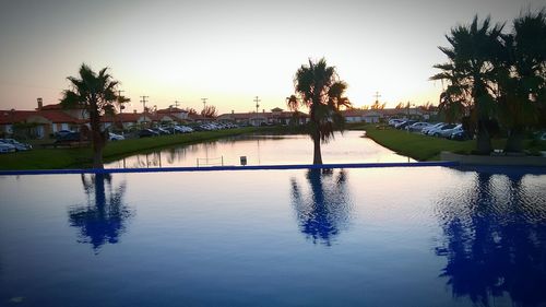 Swimming pool by lake against clear sky