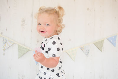 Portrait of cute smiling girl standing at home